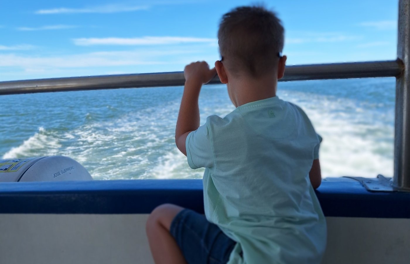 Een kind kijkt vanaf de ferry over het water van de Ria Formosa