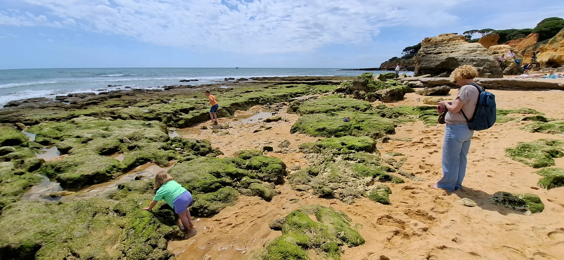 De kinderen ontdekken de rotsen langs de kust van de Algarve